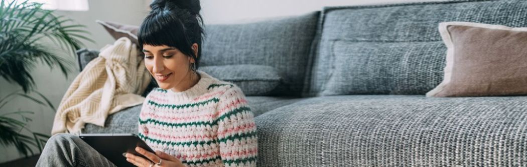 A woman researches saving money for emergencies on her tablet.