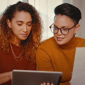 Two women discuss their finances with a Patelco Home Loan Consultant.