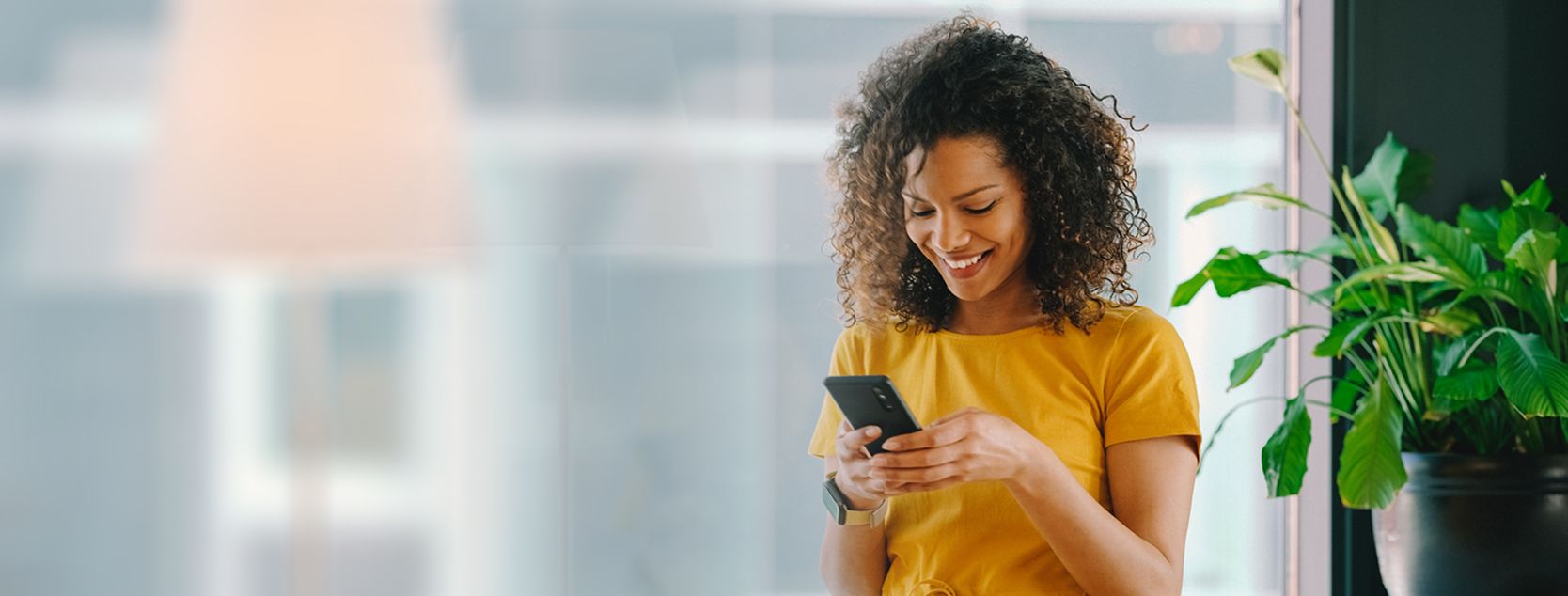 A woman manages her banking accounts using the Patelco mobile app on her phone.