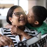 Patelco member Jane gets a kiss on the cheek from her son.