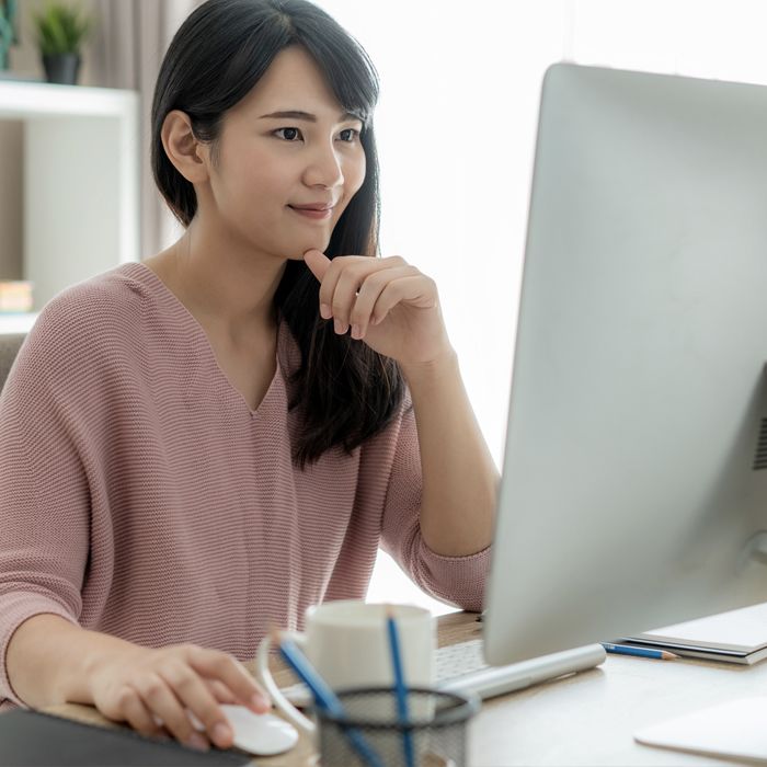 A woman sets up an international wire transfer from her desktop computer.