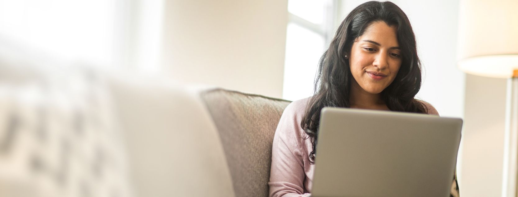 A brown-haired woman reviews her Patelco Online banking statement.