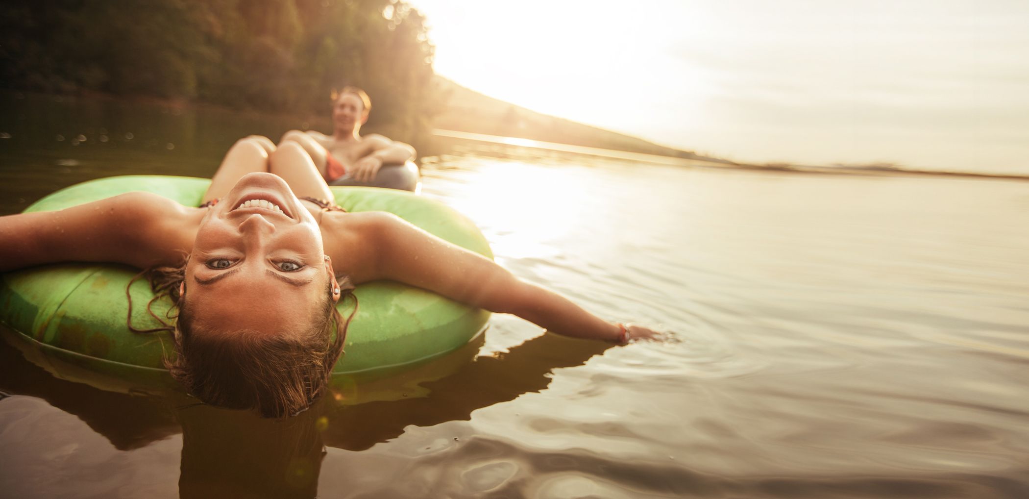 Young couple enjoying inflatable tubes outside on the water