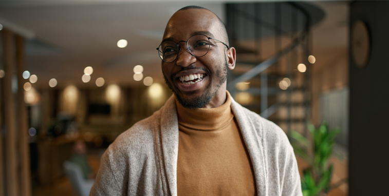 A new home owner smiles from his living room.