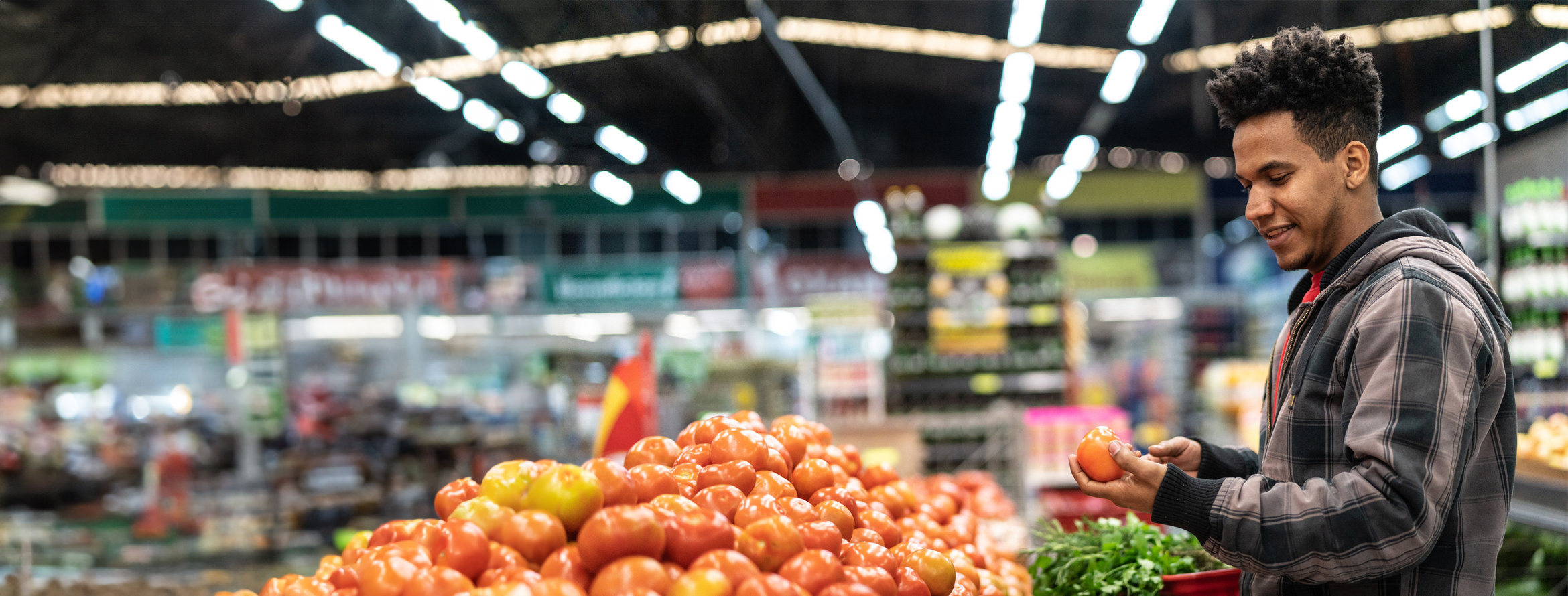 Man at the grocery store looking at produce with a smile