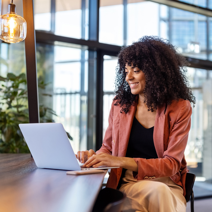 A woman using the Patelco certificate renewal feature on her laptop